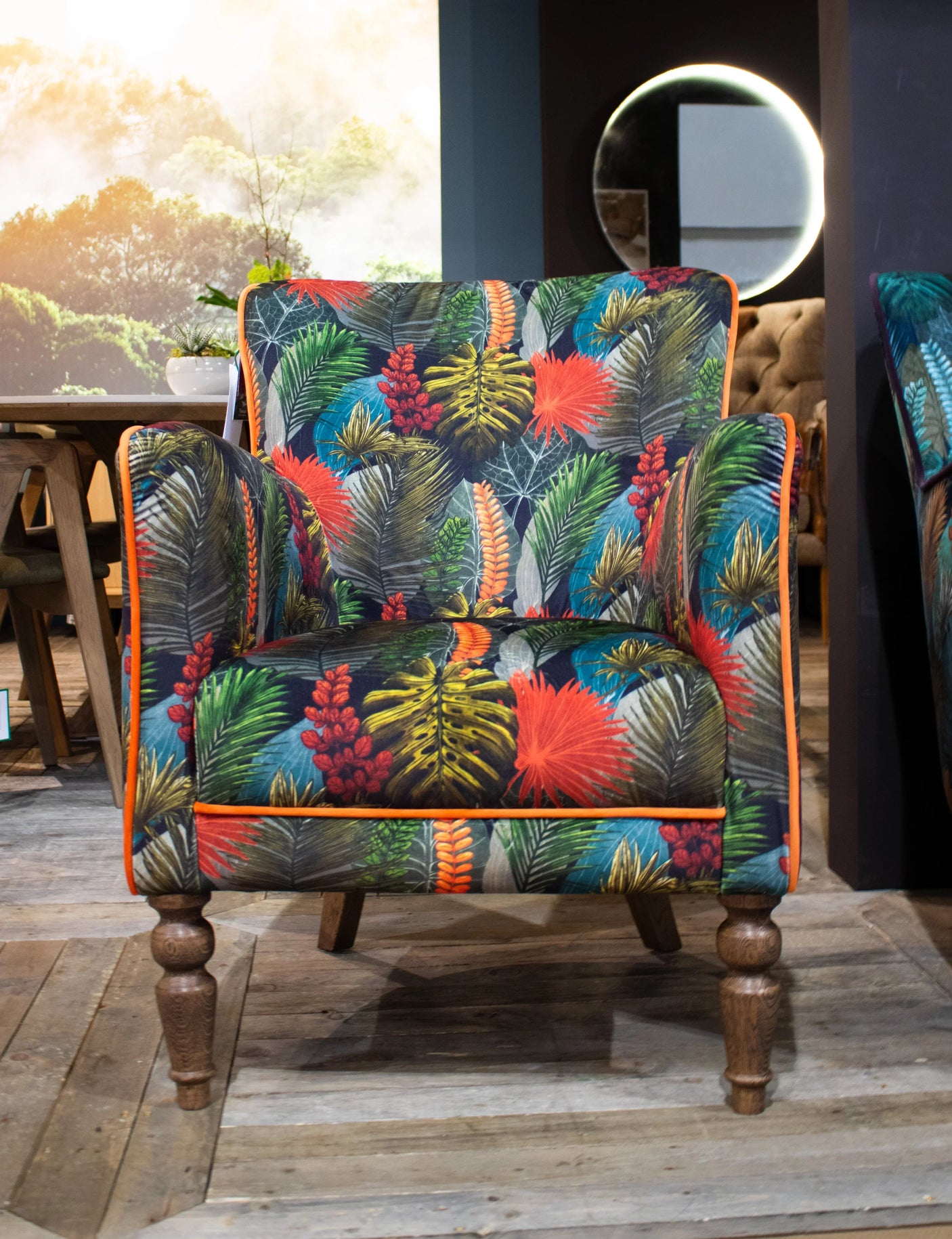 Tropical print accent armchair with wooden legs in living room setting