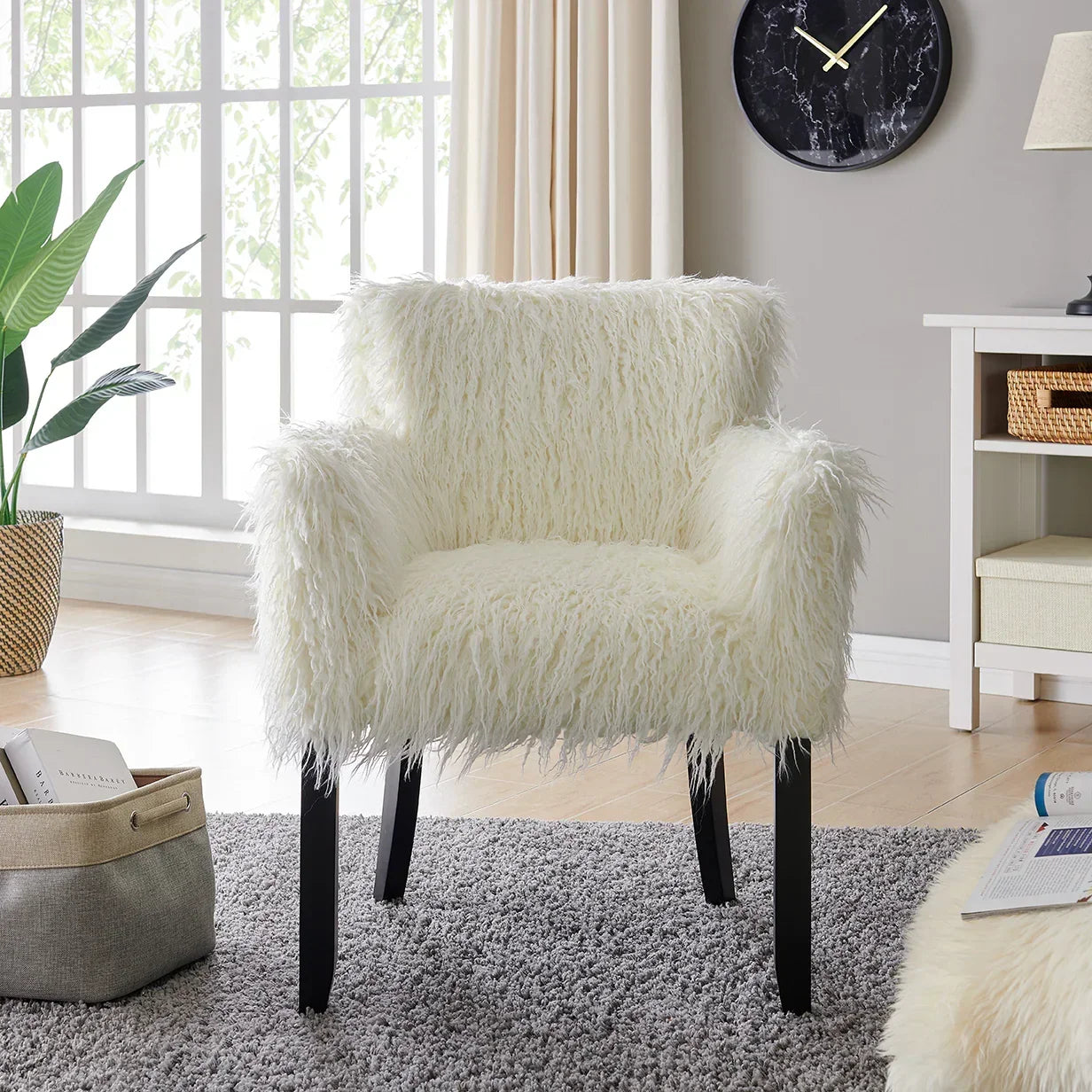Ivory faux fur accent chair with black legs on grey rug in bright living room