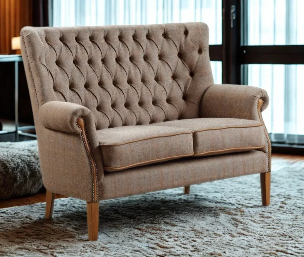 Brown fabric sofa with button-tufted backrest and wooden legs on a plush rug