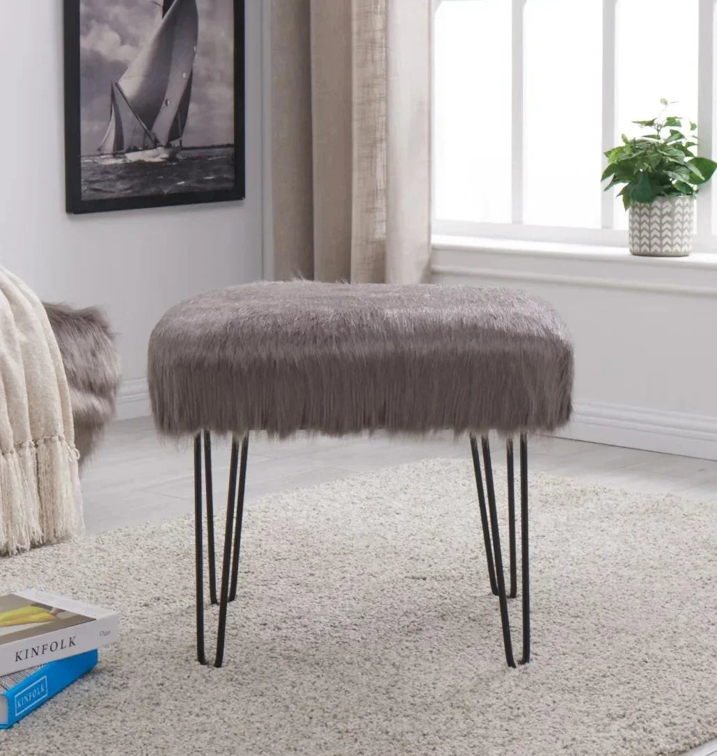 Grey faux fur stool with metal hairpin legs on a light rug in a modern living room