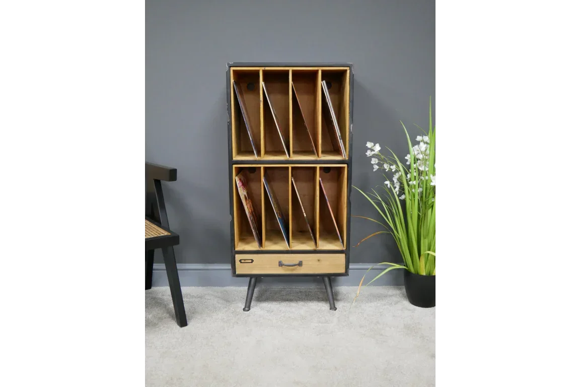Wooden vinyl record storage unit with metal legs and lower drawer against grey wall