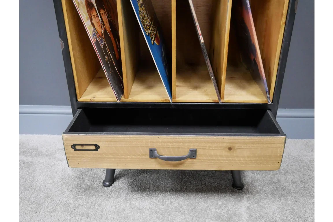 Wood and metal record storage unit with vinyl dividers and open drawer on carpeted floor