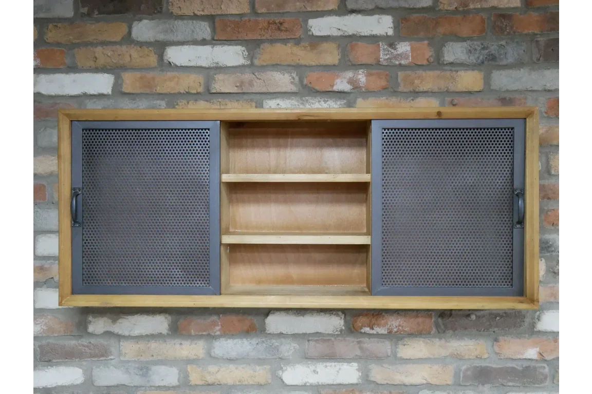 Industrial wall cabinet with mesh metal sliding doors and wooden shelving against brick wall