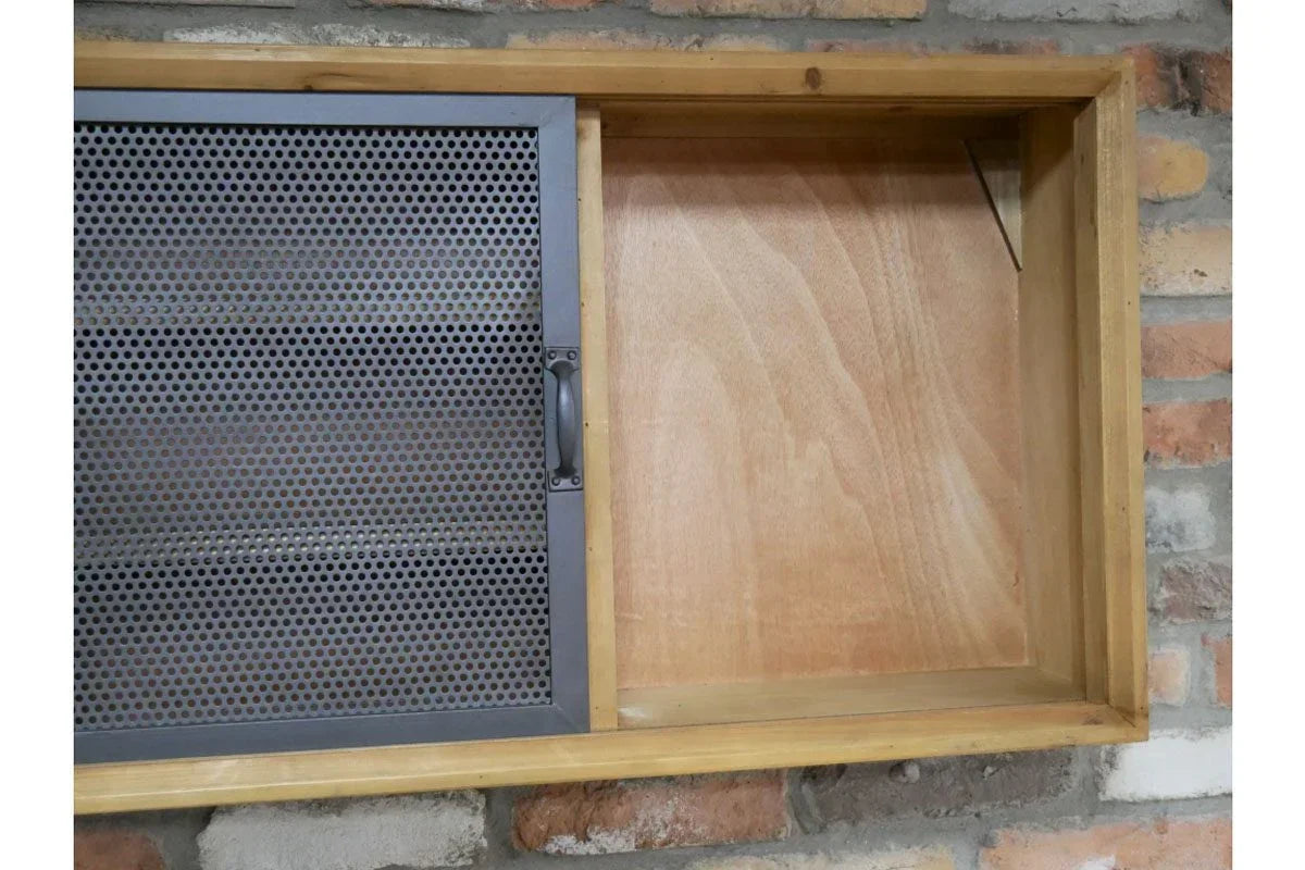 Industrial wall cabinet with metal mesh sliding door and wood frame against brick backdrop