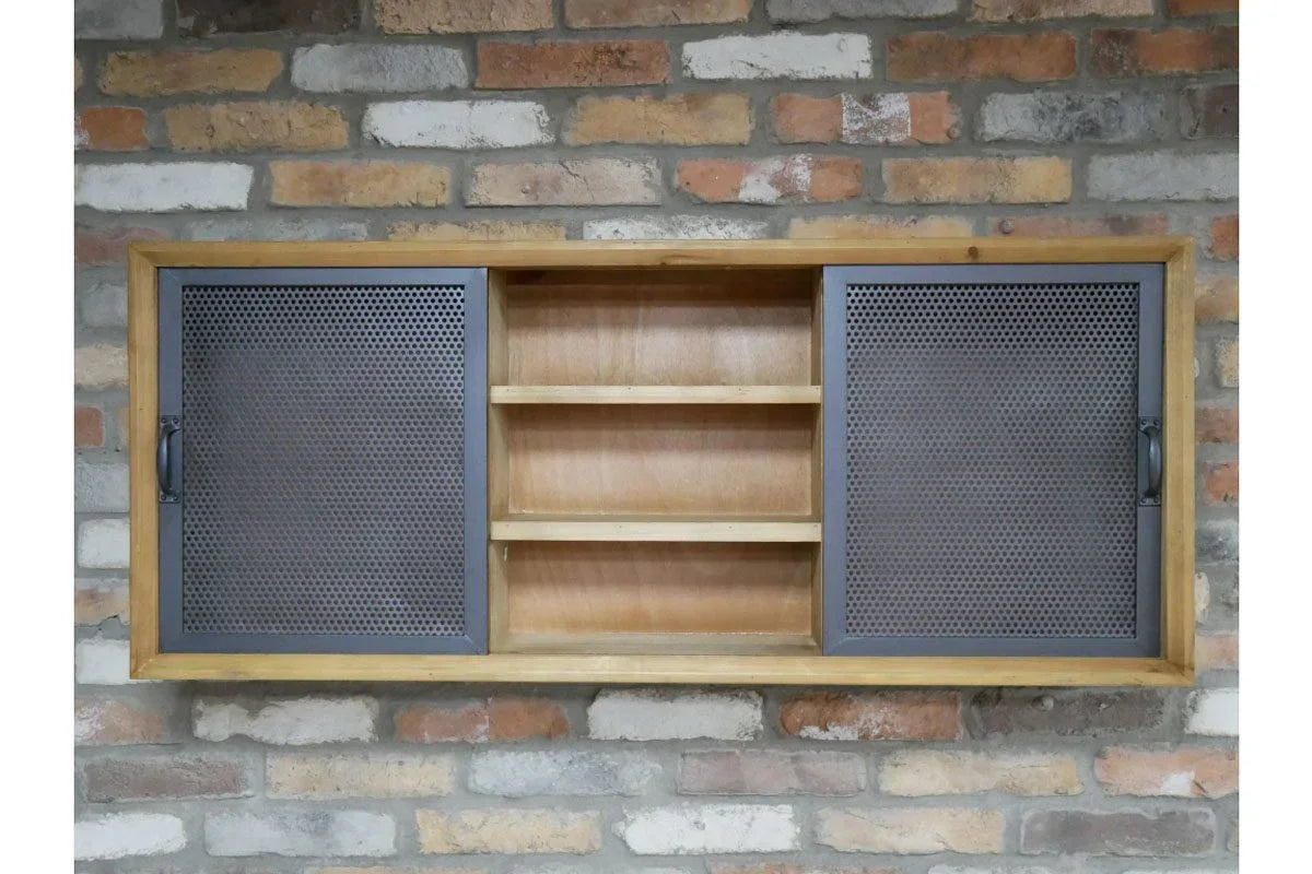 Industrial wall cabinet with mesh sliding doors and wooden shelves mounted on brick wall