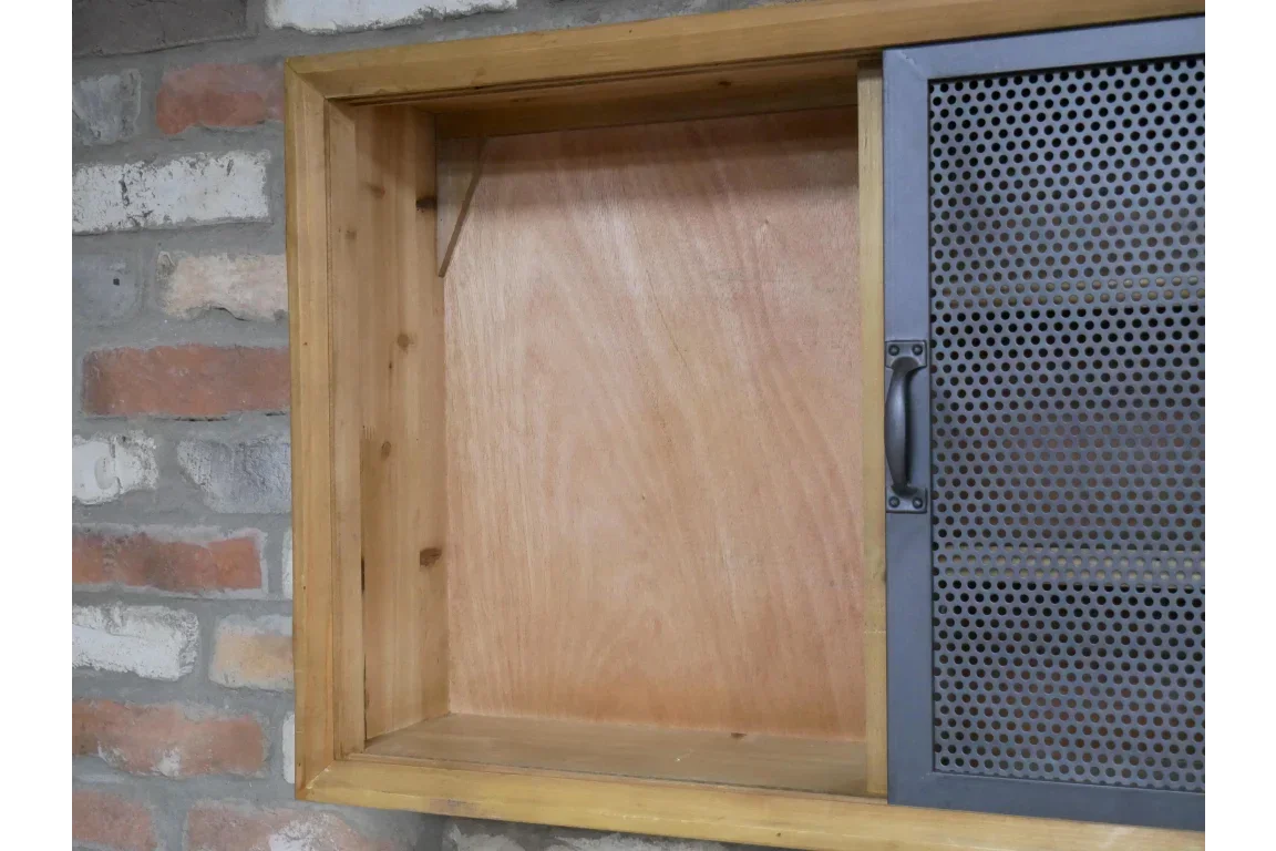 Industrial wooden wall cabinet with black metal mesh door and handle, mounted on brick wall