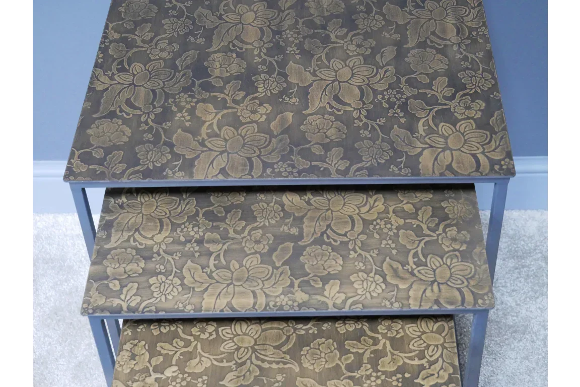 Nested wooden tables with floral pattern tops in gold on brown finish