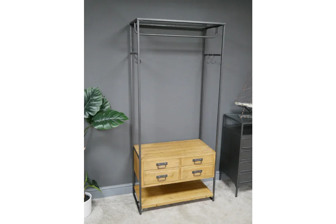 Industrial clothes rail with wooden drawers and metal frame against grey wall