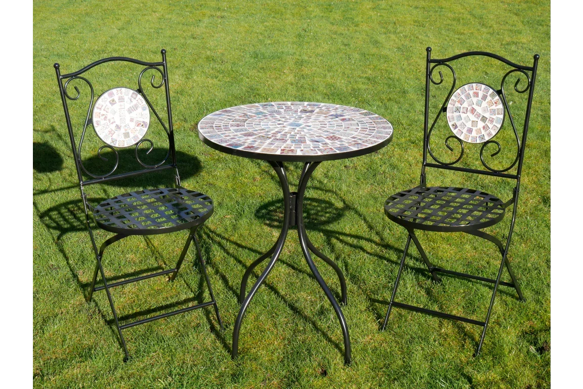 Outdoor mosaic bistro set with round table and two metal chairs on grass