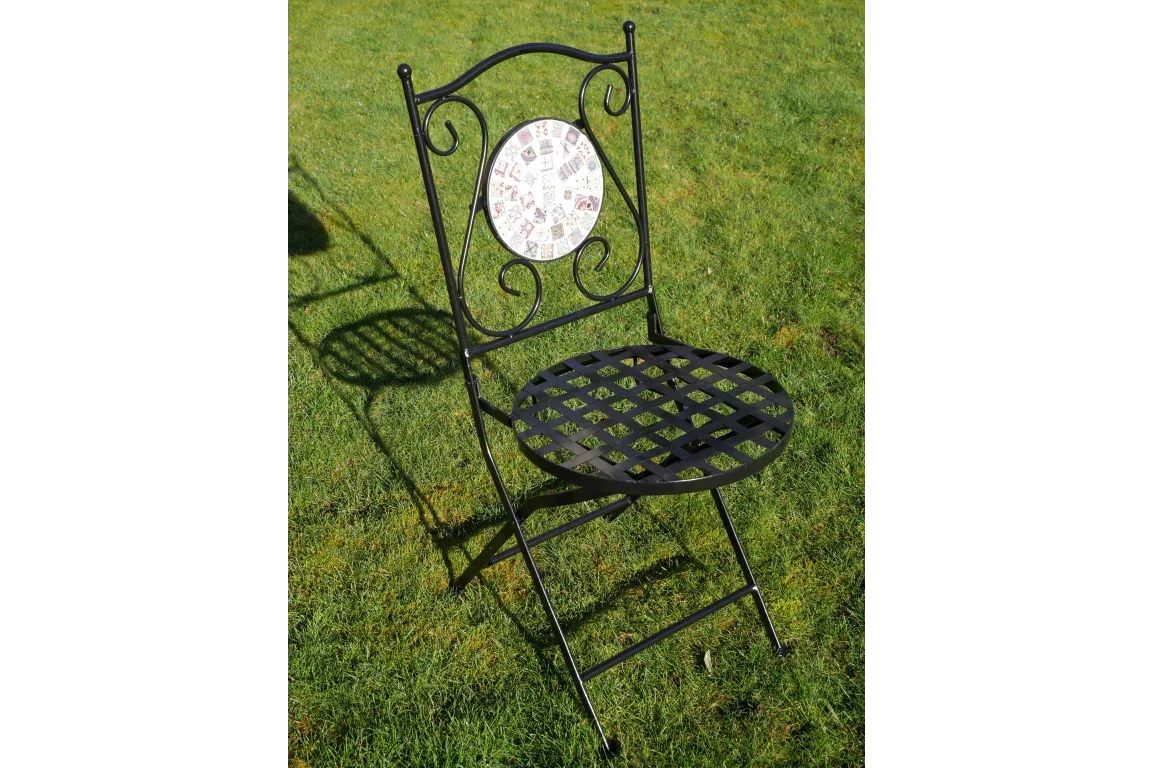 Black wrought iron garden chair with mosaic backrest on grass