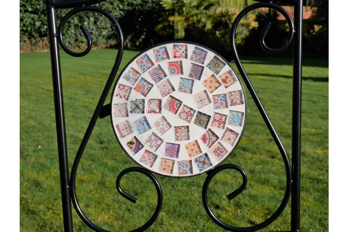 Mosaic garden table top with colorful patterned tiles and black metal frame outdoors