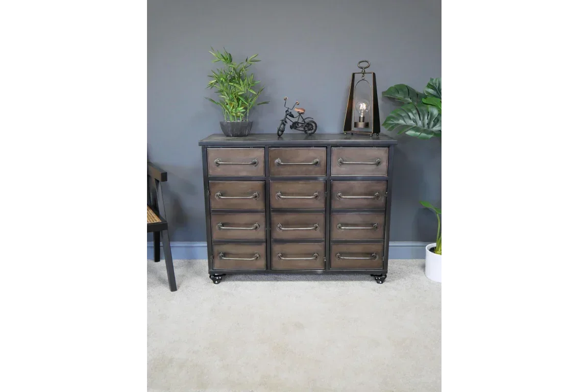 Industrial style chest of drawers with metal handles and decor plants against grey wall