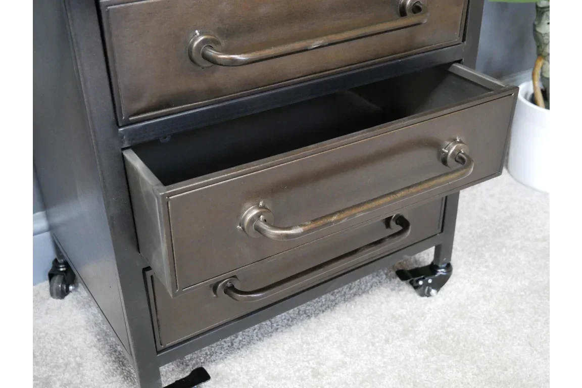 Metal storage cabinet with open drawer, industrial handles and caster wheels on carpet