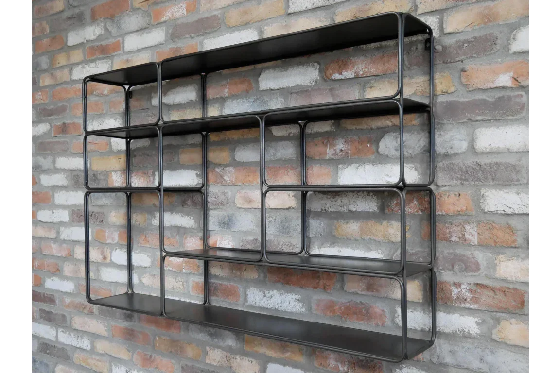 Black metal wall shelf with open rectangular compartments on exposed brick wall