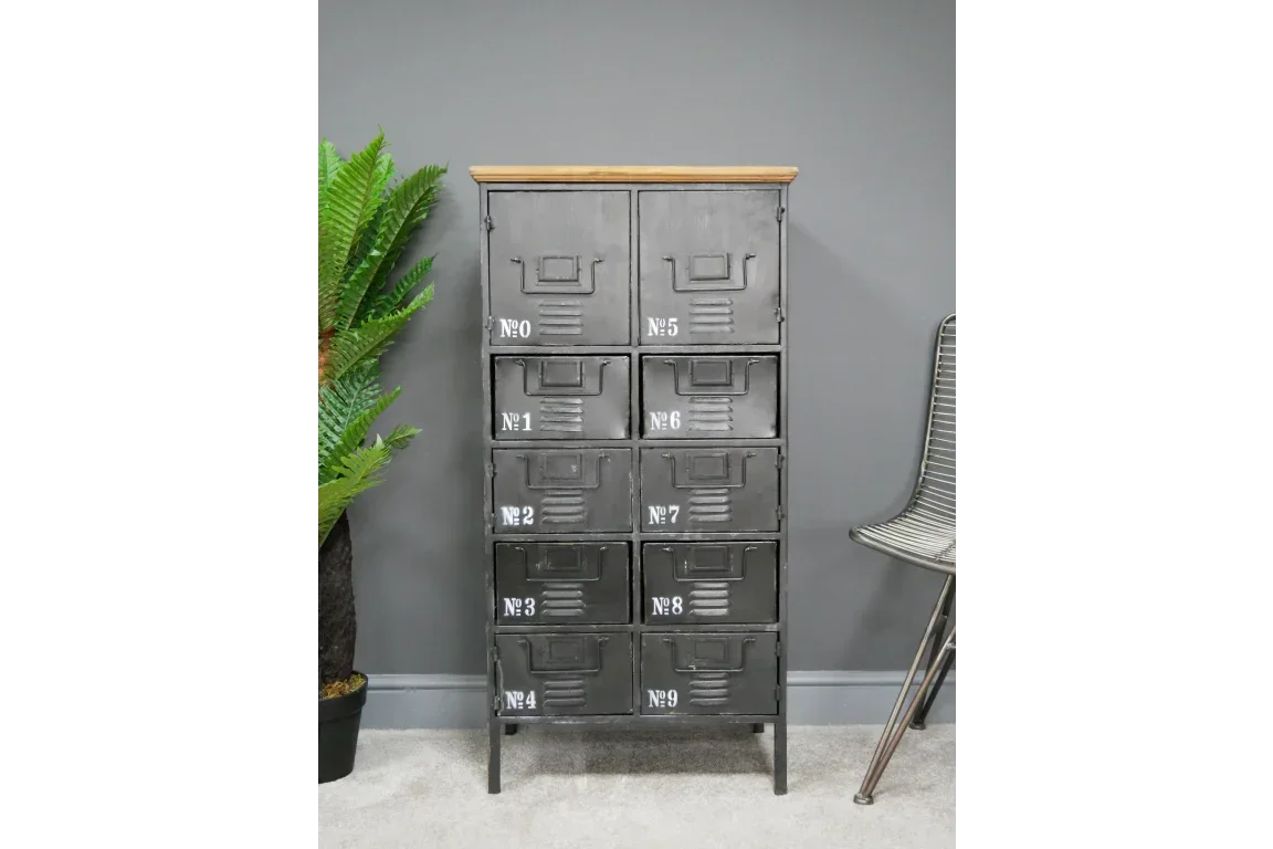 Industrial metal storage cabinet with numbered drawers and wood top against grey wall
