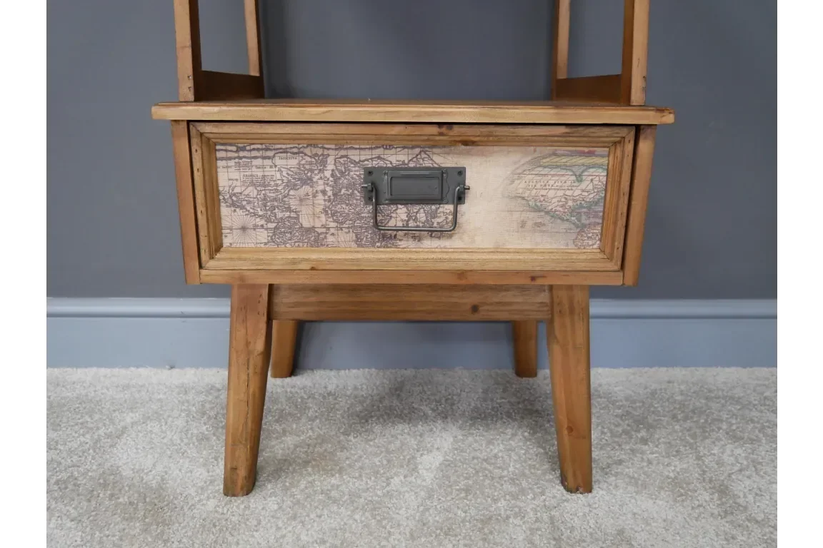Wooden side table with vintage map drawer front and metal handle on carpeted floor