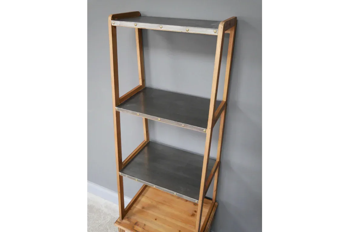 Industrial shelving unit with black shelves and wood frame against grey wall