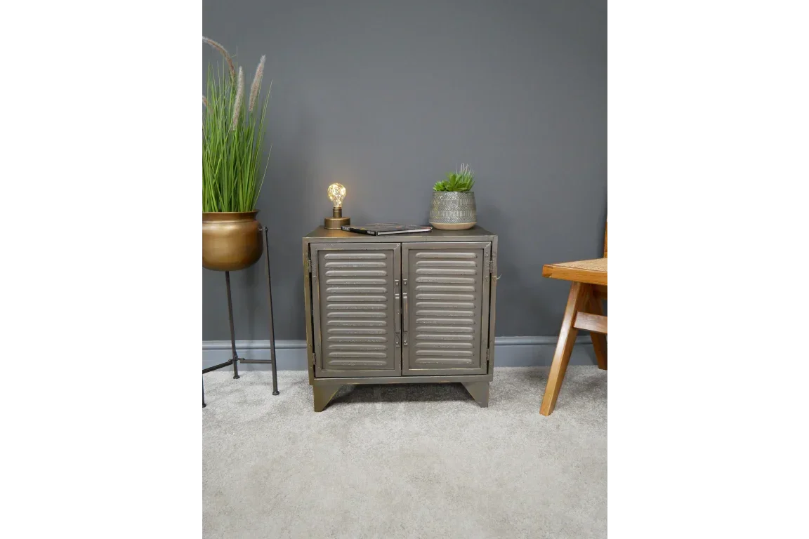 Metal storage cabinet with double shutter doors, styled with lamp and plant on grey wall