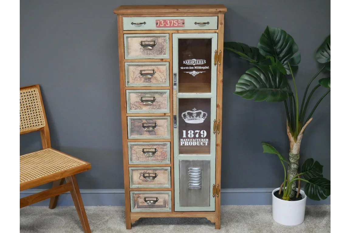 Vintage multi-drawer storage cabinet with glass door and printed maps, against a grey wall