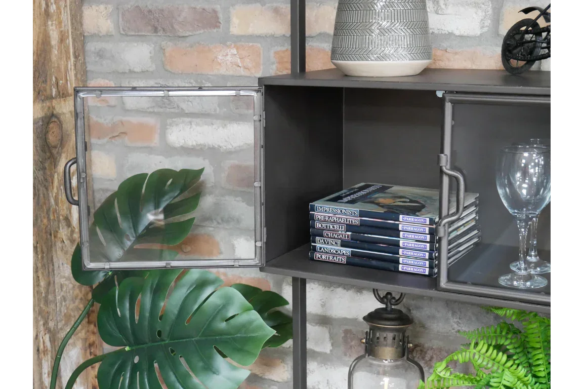 Industrial style metal cabinet with glass door, books and wine glasses on exposed brick wall