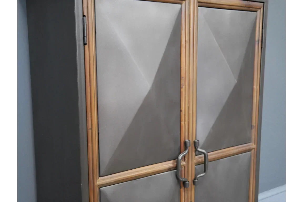 Metal and wood storage cabinet with geometric doors and black handles against blue wall