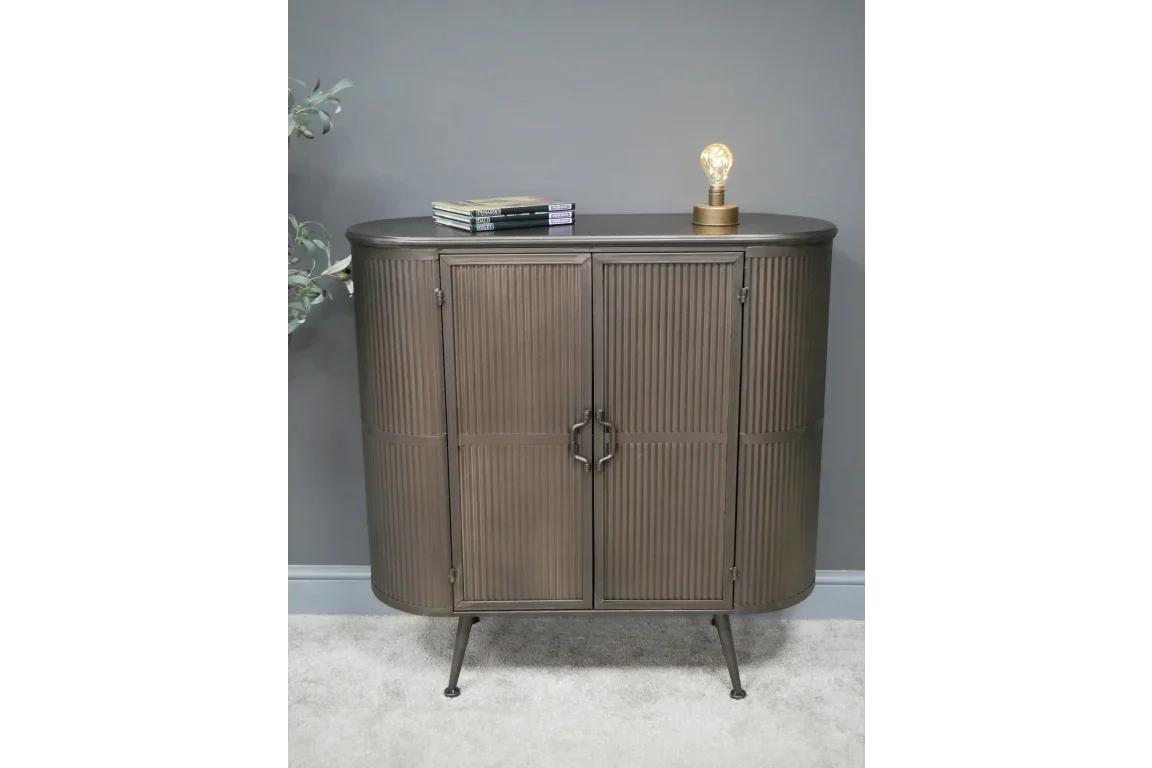 Metal sideboard cabinet with ribbed doors and hairpin legs against grey wall