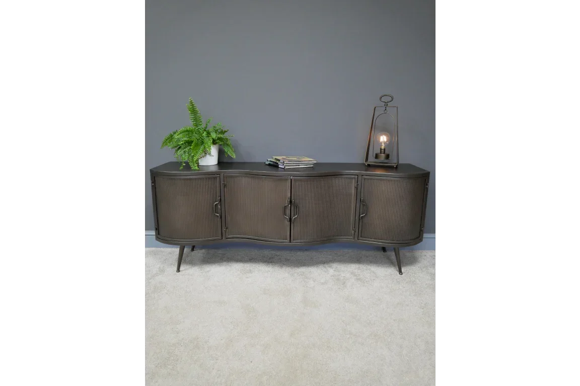 Dark wood sideboard with four doors, black legs, decorated with plant, lamp and magazines