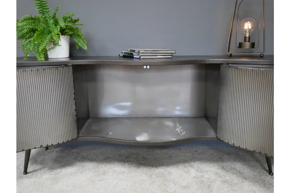 Metallic sideboard with ribbed doors, open shelf, potted plant and lamp on top