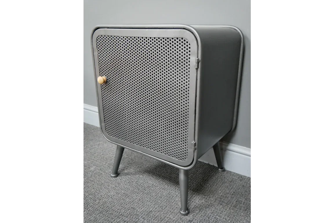 Grey metal bedside cabinet with perforated door and wooden knob on carpeted floor