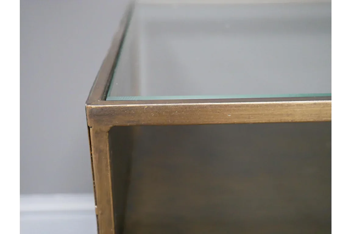 Close up of glass coffee table with gold metal frame corner