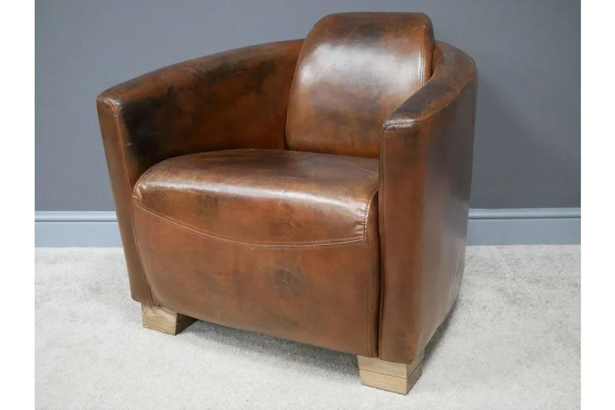 Brown leather armchair with curved arms and wooden block legs on light carpet