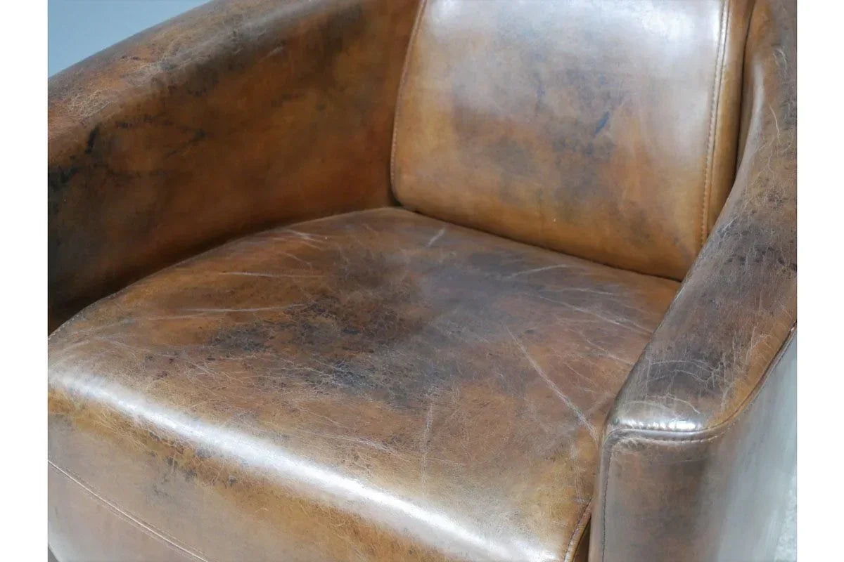 Distressed brown leather armchair seat and backrest close-up