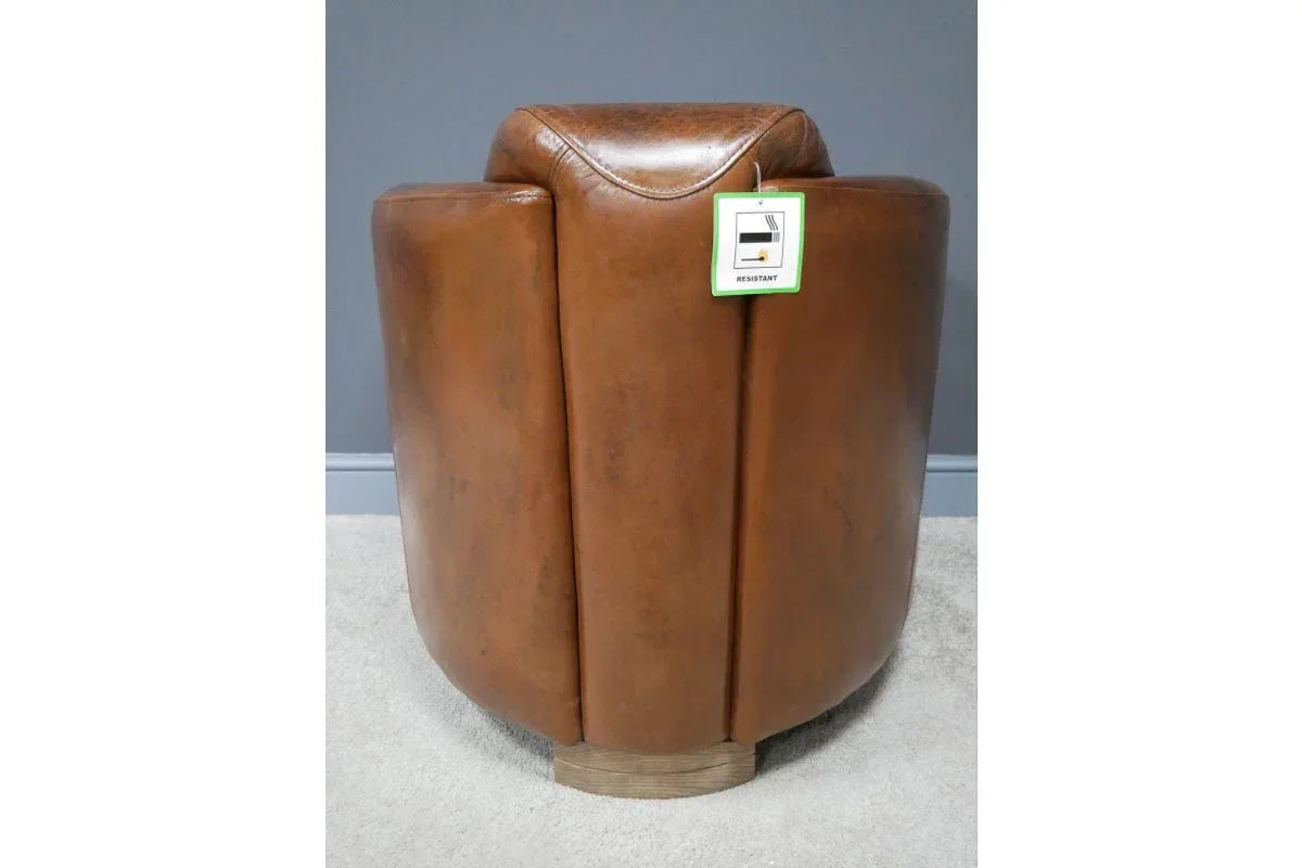Brown leather armchair rear view with tag on light carpet and grey wall background