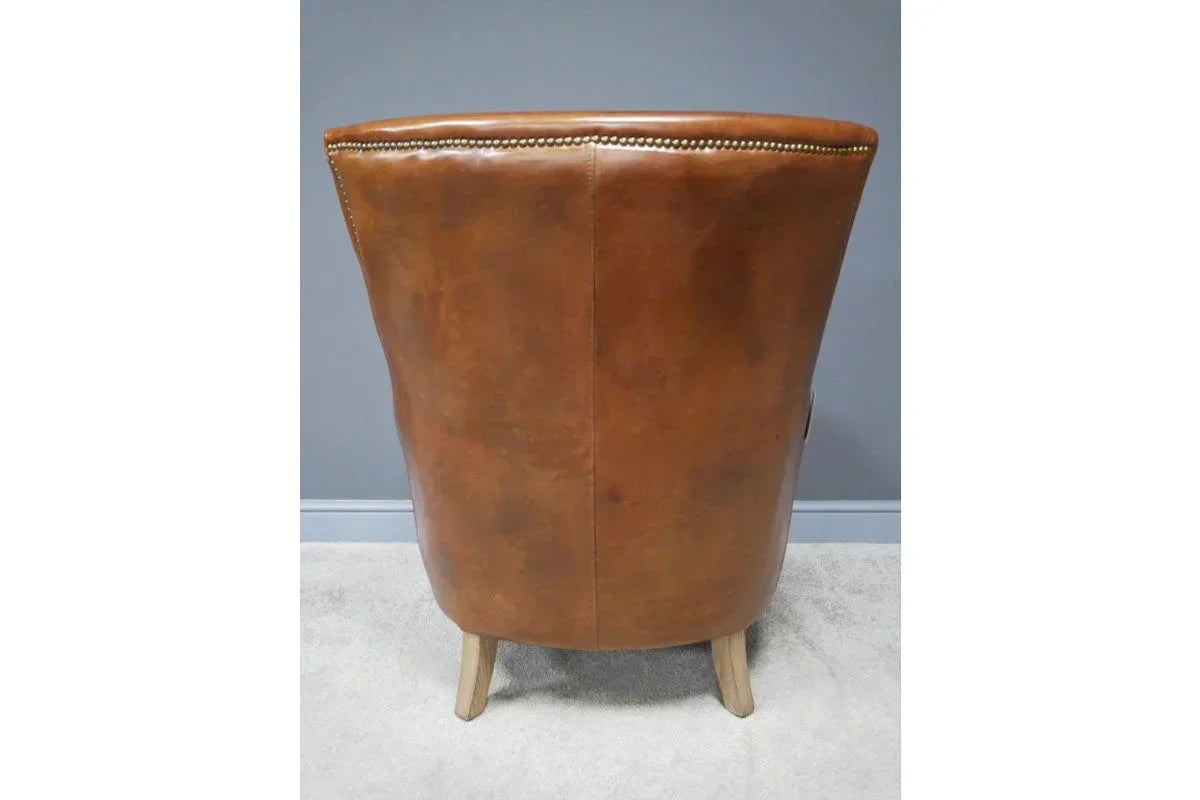 Back view of brown leather accent chair with wooden legs on carpet