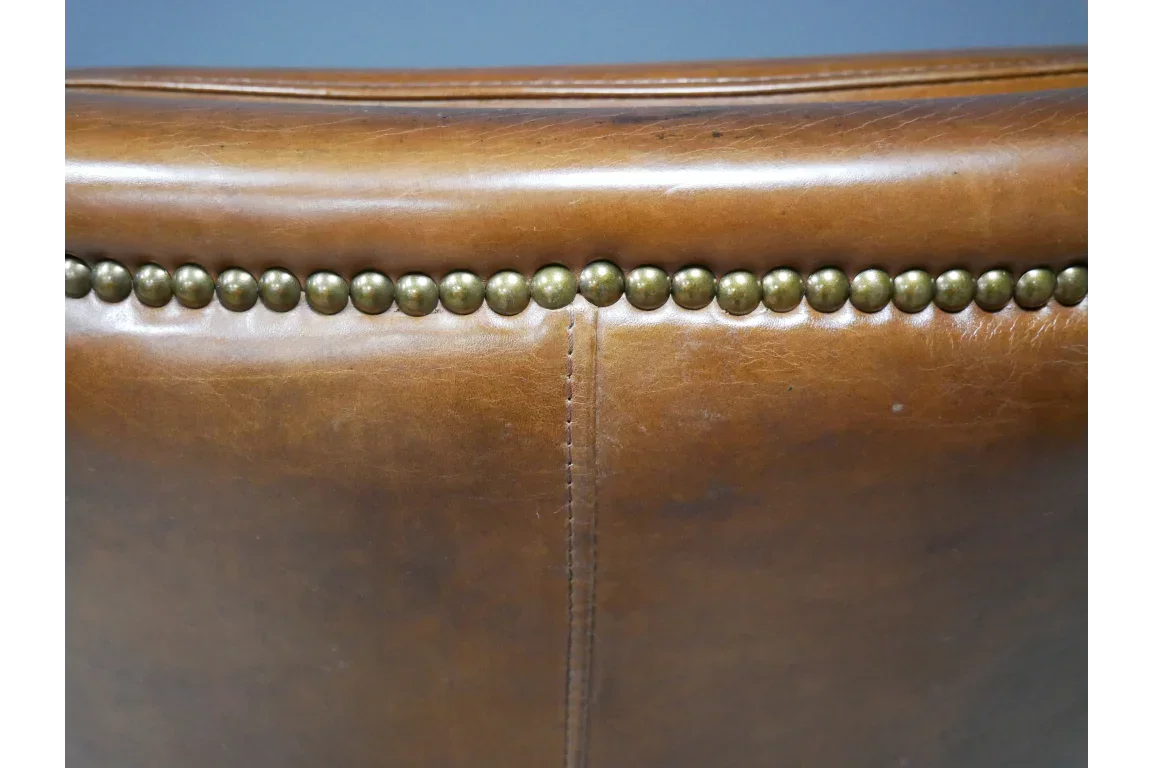 Close up of brown leather chair back with brass stud detailing