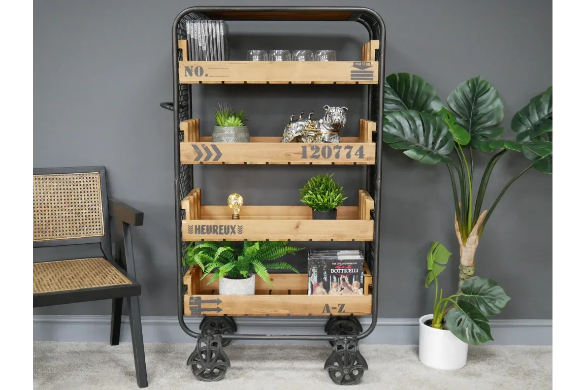 Industrial style wooden storage shelf unit with metal frame and wheels, styled with decor