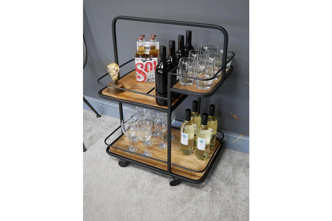Industrial style drinks trolley with wood shelves holding bottles and glassware