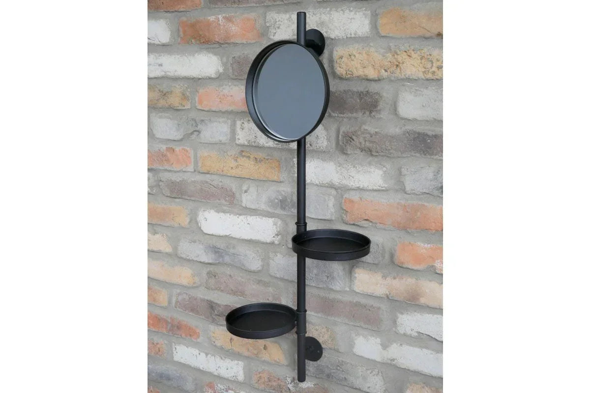 Black metal wall shelf with round mirror and two trays mounted on brick wall