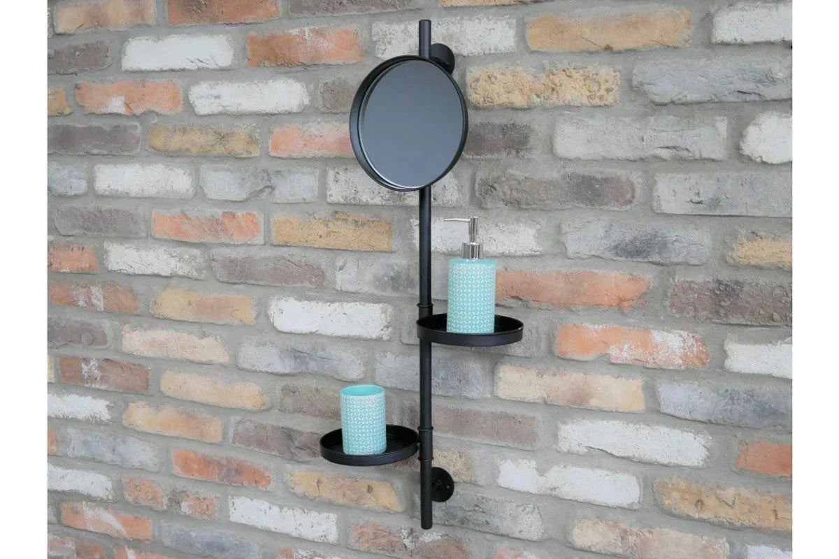 Black metal wall shelf with mirror and two trays holding blue accessories on brick wall