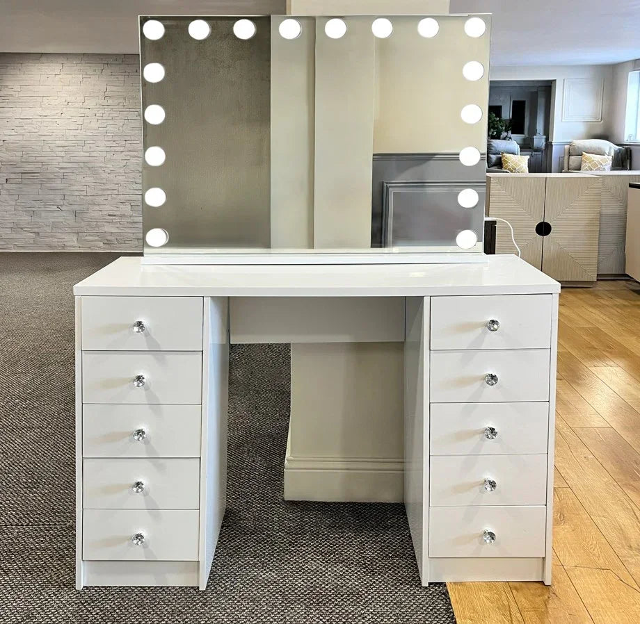 White dressing table with ten drawers and large mirror surrounded by LED lights