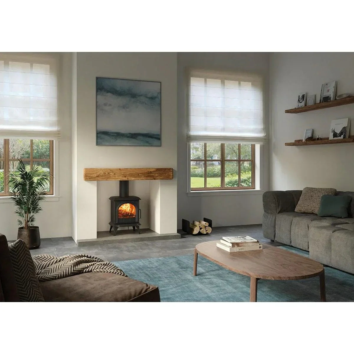 Modern living room with grey sofa, wood burning stove, coffee table and large windows