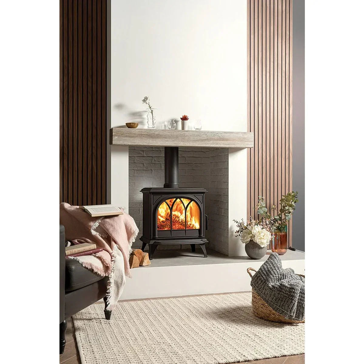 Black wood burning stove with glass doors in modern living room fireplace setting