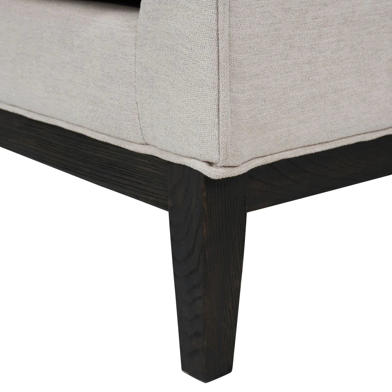 Ivory fabric armchair corner with dark wooden leg detail.