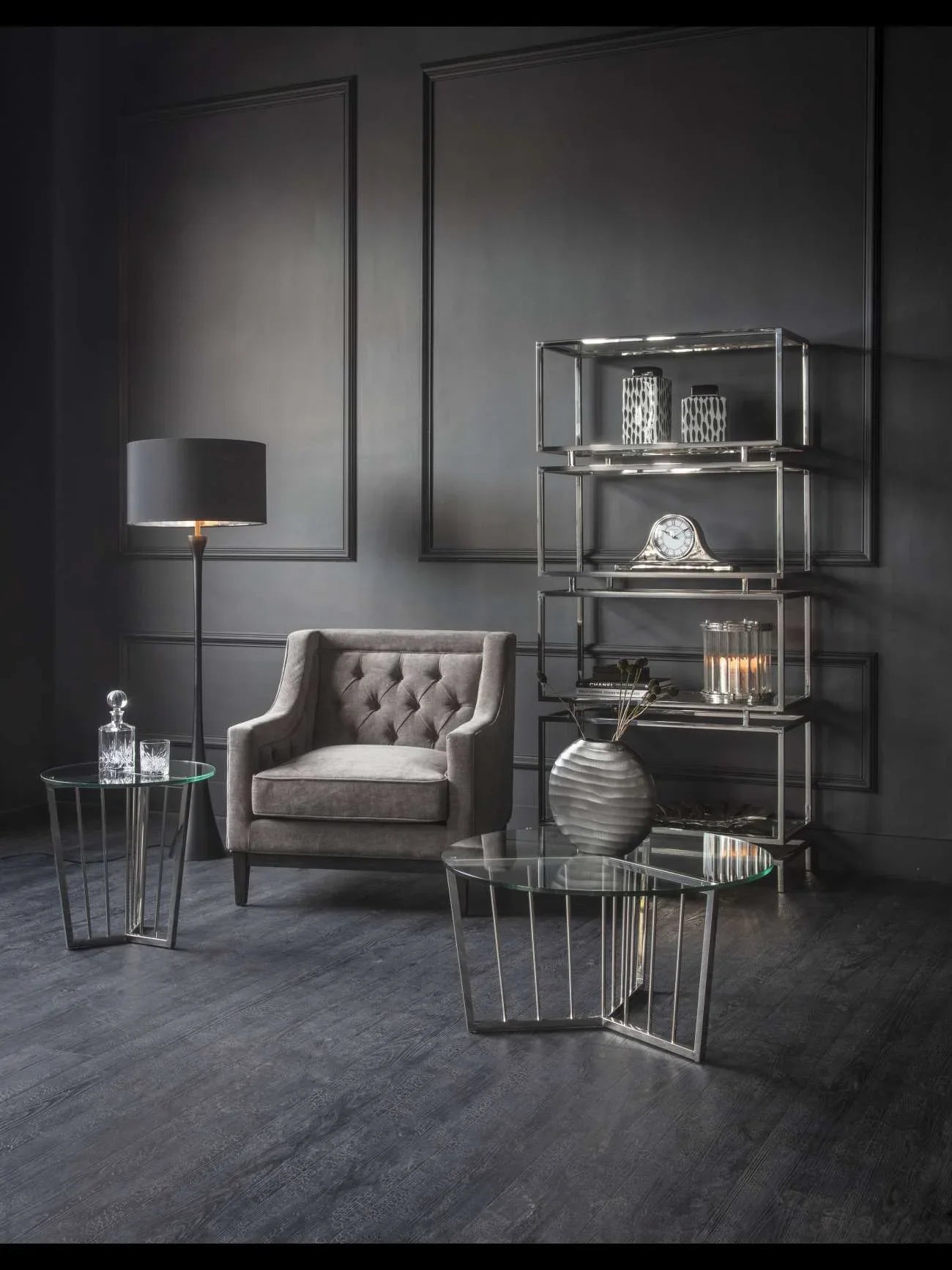 Warm grey armchair in elegant living room with glass tables and modern decor.