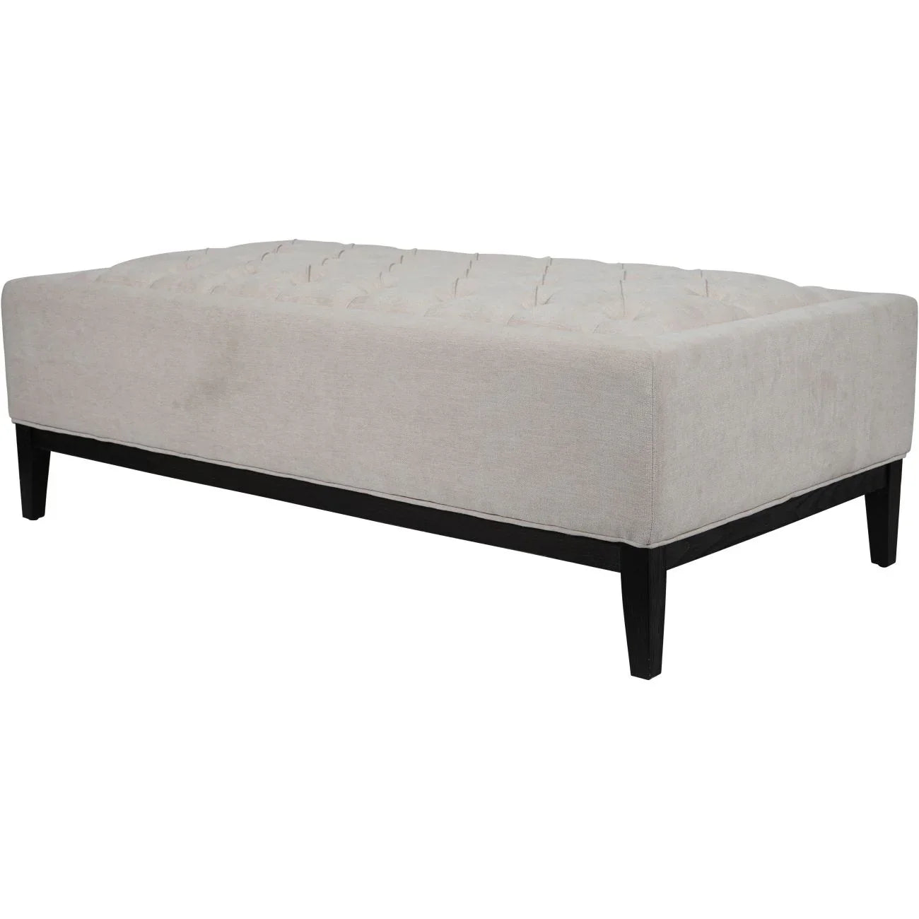 Ivory fabric ottoman with buttoned top and dark wooden legs.
