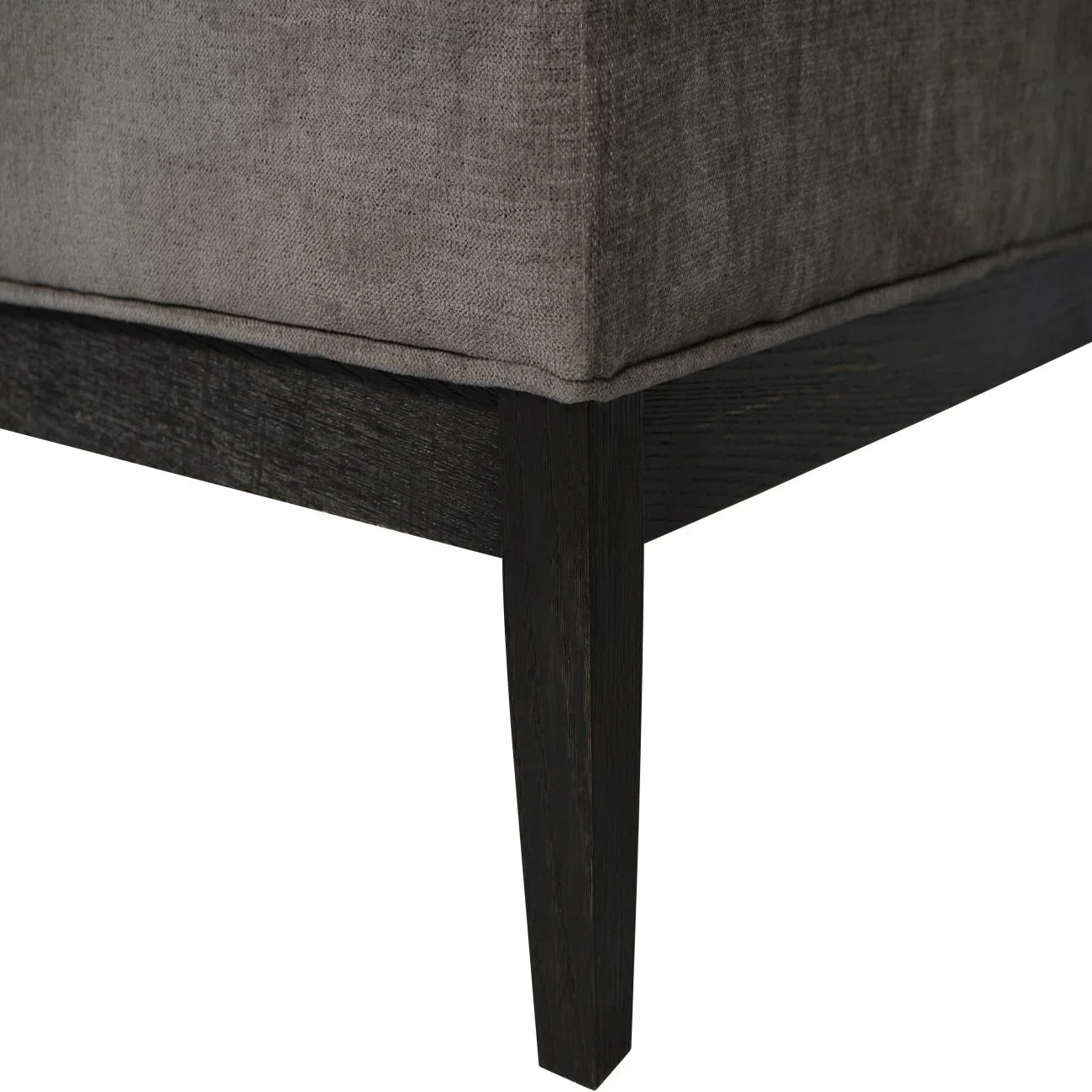 Dark wood leg of grey fabric ottoman showing corner detail.