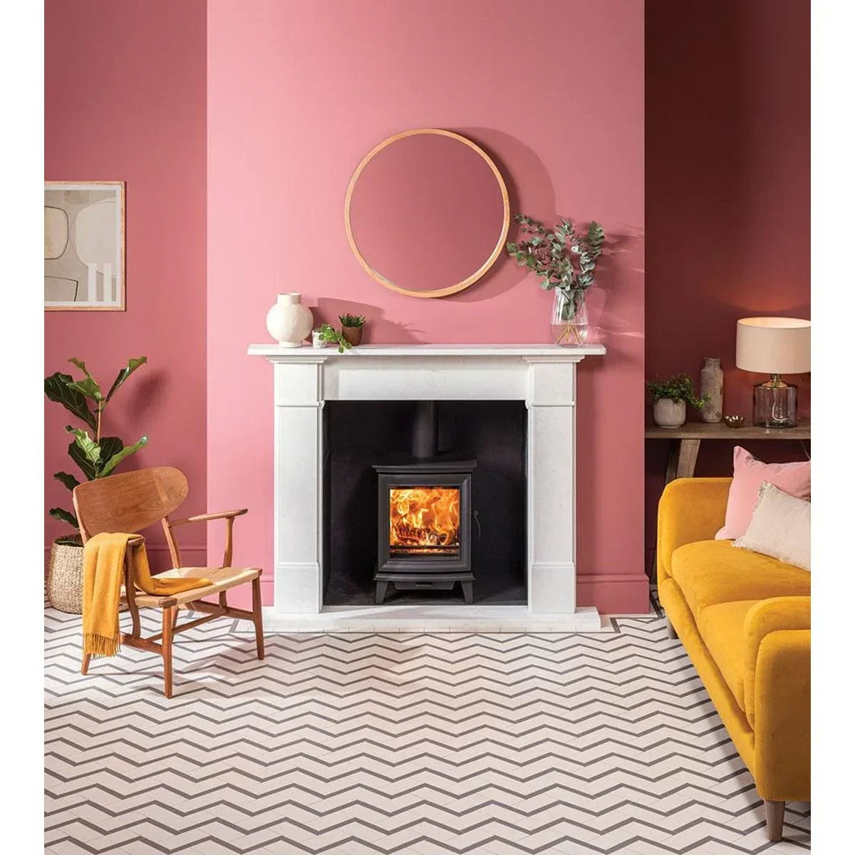 Modern living room with yellow sofa, wood burning stove, and chevron patterned flooring