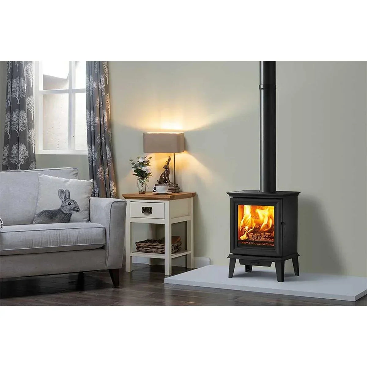 Black wood burning stove in modern living room with grey sofa and side table