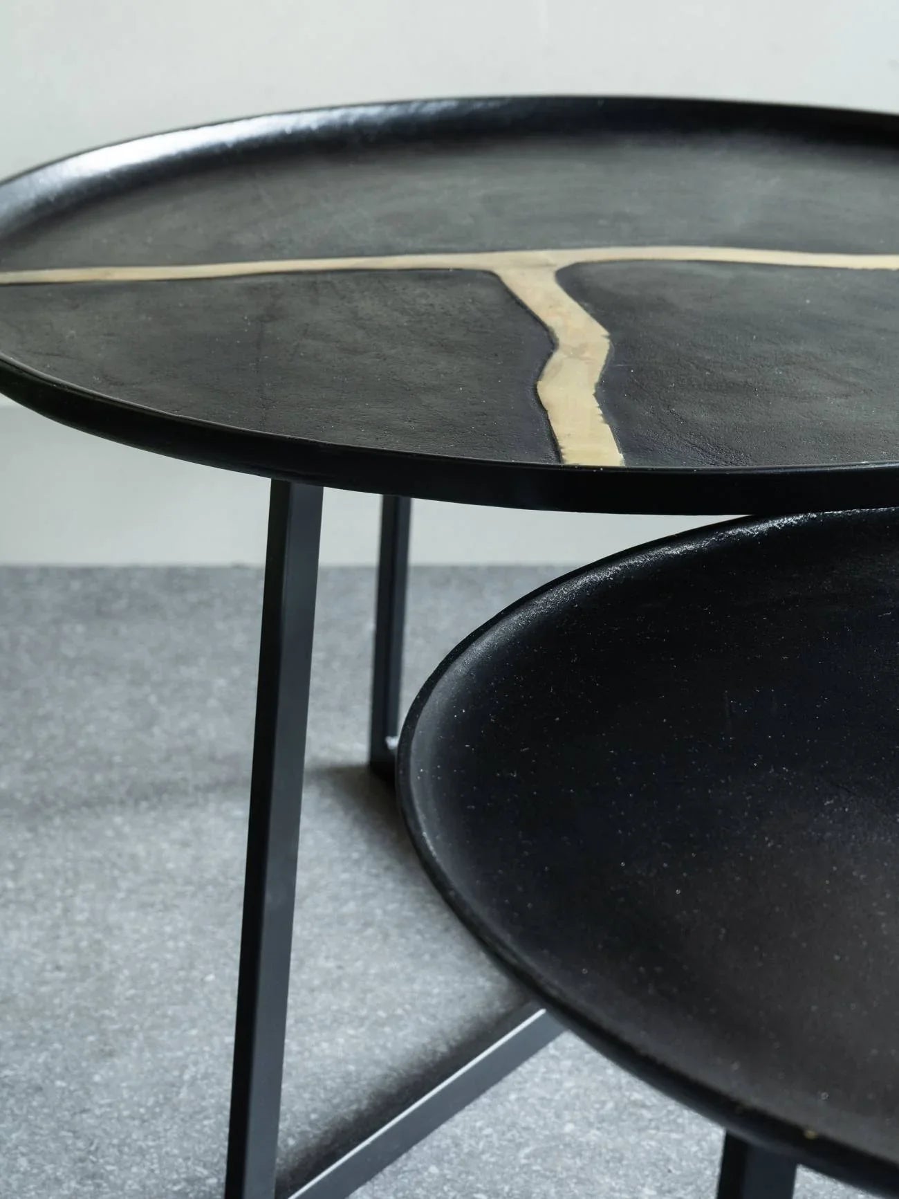 Black aluminium coffee tables with textured surfaces and unique design accents.