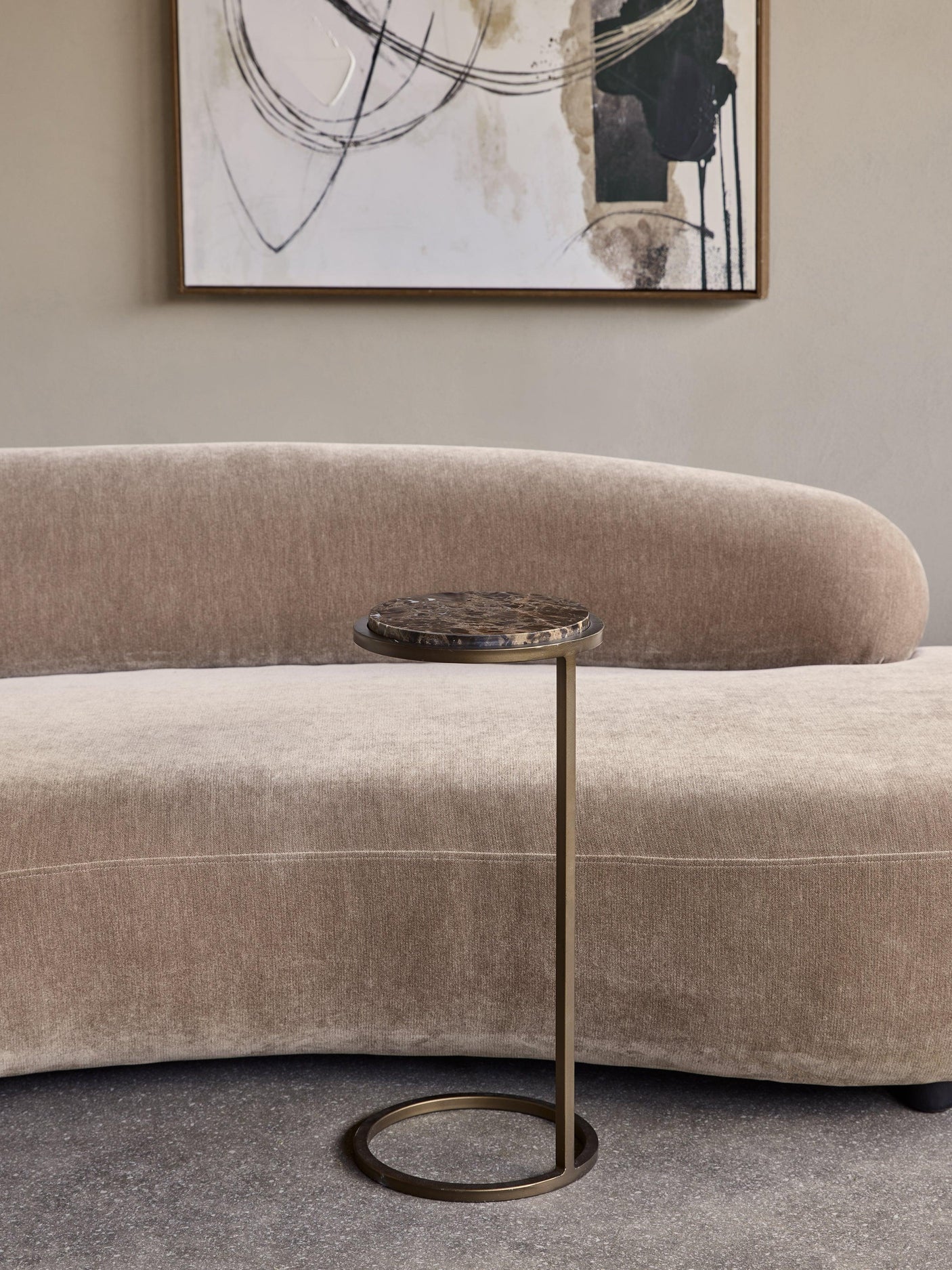 Brown marble accent table beside a beige sofa in a modern living room.